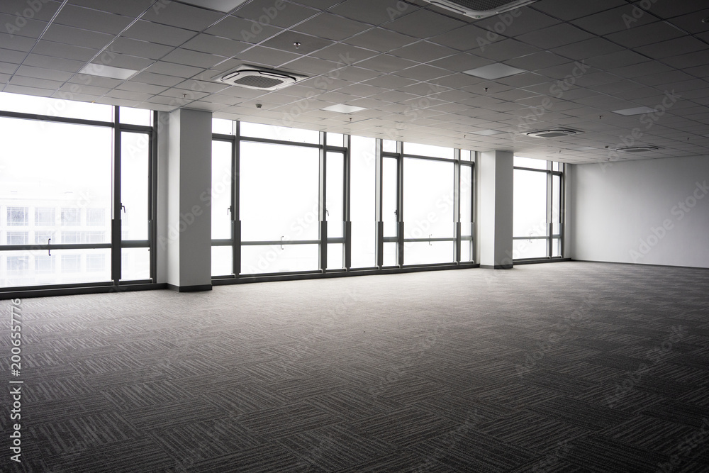 Naklejka premium Spacious modern office interior with floor-to-ceiling windows and minimalist design