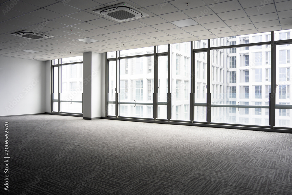 Fototapeta premium Spacious modern office interior with floor-to-ceiling windows and abundant natural light