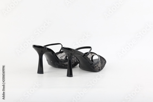 Pair of black lace high heel mules isolated on white background, studio lighting highlighting refined silhouette, delicate texture and modern feminine fashion style