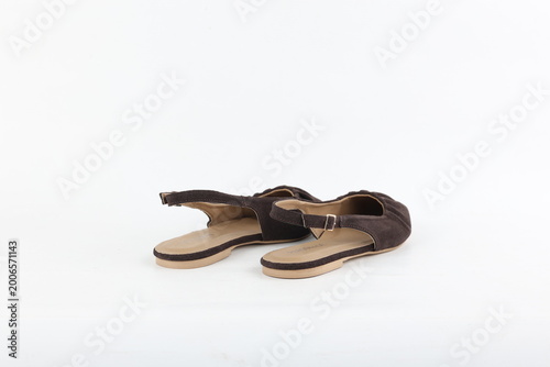 Pair of brown flat sandals isolated on white background, soft studio lighting emphasizing woven texture, open silhouette and relaxed contemporary women’s fashion style