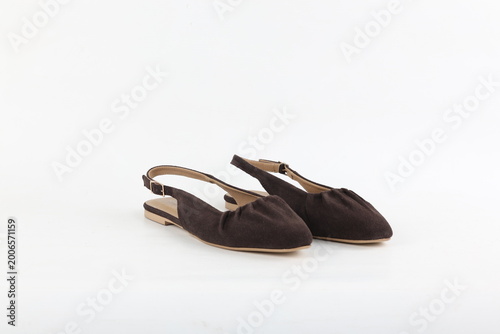 Pair of dark brown slingback flats isolated on white background, minimalist studio lighting highlighting soft texture, refined silhouette and timeless feminine fashion design