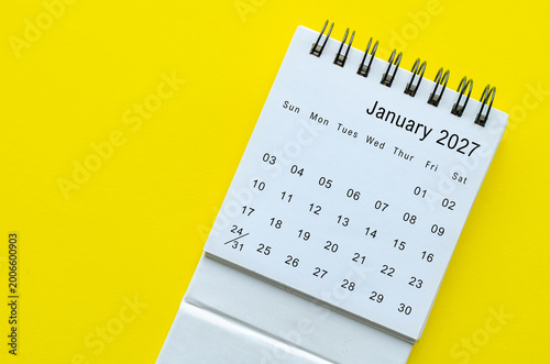 Top view of January 2027 calendar on yellow background with empty space for text.