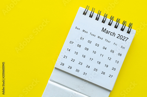 Top view of March 2027 calendar on yellow background with empty space for text.