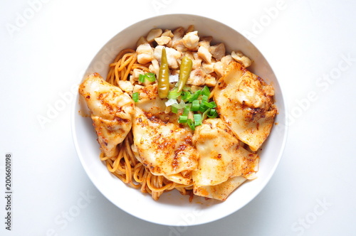 Photography Hongkong style hot chili oil noodles with dumplings served in a white bowl at a