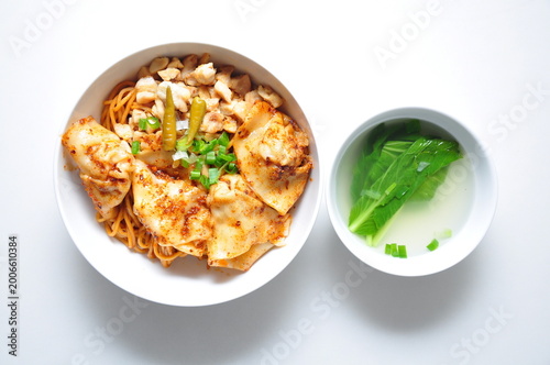 Photography Hongkong style hot chili oil noodles with dumplings served in a white bowl at a