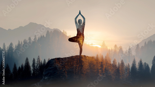 Double exposure silhouette of a person in a yoga tree pose merged with a dense pine forest and mountain landscape during a peaceful sunset, symbolizing harmony with nature.