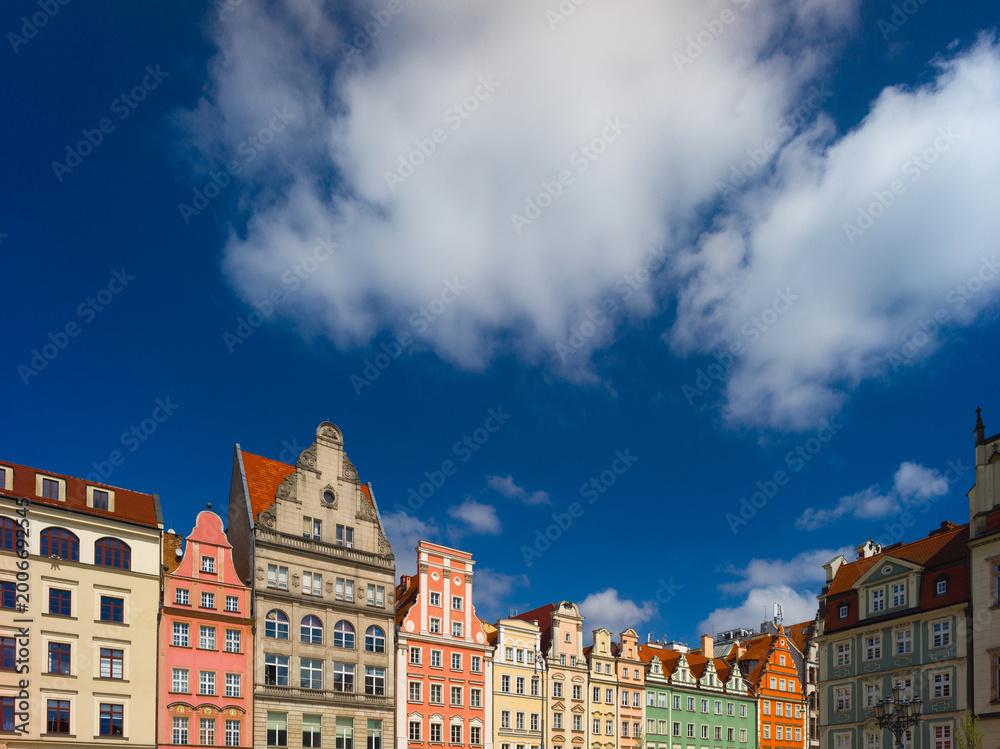 Fototapeta premium Wroclaw, Poland, 24th April 2026, old town market square in rynex with colourfull house facades and shop fronts of different colours against blue sky