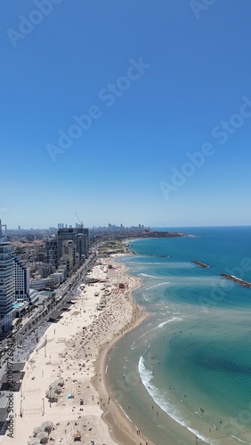 Obraz na płótnie Aerial 4K view of Tel Aviv coastline, bustling promenade, luxury hotels, and san