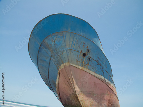 Abandoned shipwreck hull resting on tropical beach sand