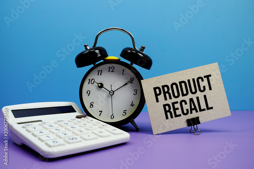 Foto Product Recall text with calculator and alarm clock on blue and purple backgroun
