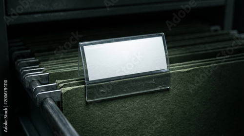 Tableau sur toile Blank White Label In Plastic Holder On Green Hanging File Folder