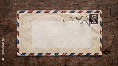 Foto Vintage Airmail Envelope With Blank Label Resting On Wooden Desk