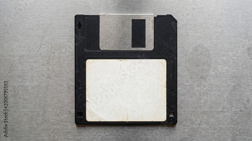 Konstfotografi Vintage Floppy Disk With Blank Label Resting On Scratched Metal