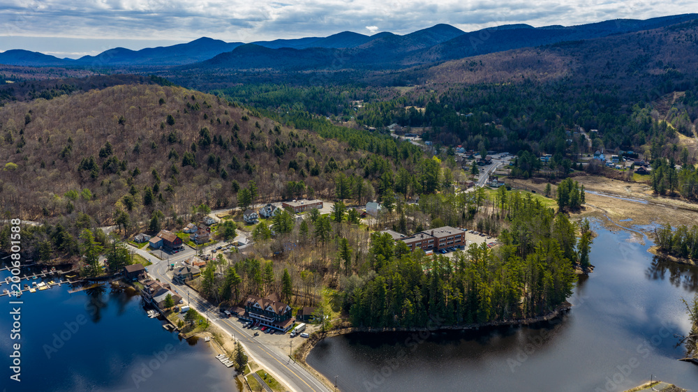 Obraz premium Long Lake, NY, USA April 29, 2026 Aerial photograph captures the scenic hamlet of Long Lake and Raquette River in the heart of New York's Adirondack Mountains.