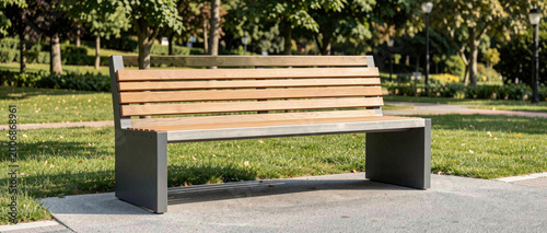 A simple wooden bench situated in the center of a green park