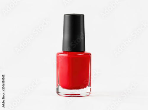 A bottle of red nail polish on a white background