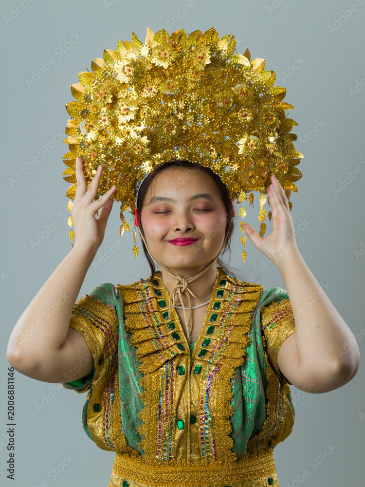 Fototapeta premium Young Woman Wearing Traditional Golden Southeast Asian Headdress and Ornate Costume, Portrait