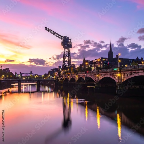 A serene cityscape at sunset with a bridge over a river