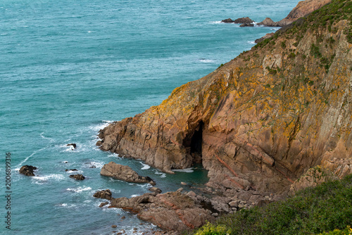 Rocky coastal cliffs turquoise ocean waves green vegetation Ireland UK