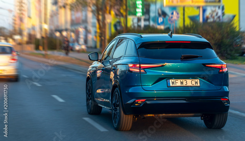 Obraz na plátně Dark blue crossover driving on a city street