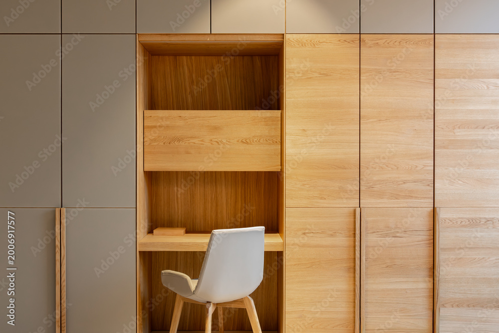 Fototapeta premium Built-in wooden workspace inside a cabinet. Stylish office interior design.