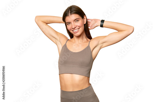 Woman exercising in crop top and leggings wearing fitness tracker to check calories and pulse