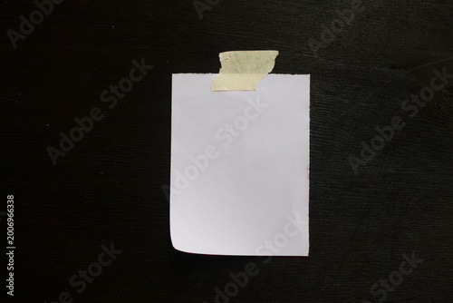 Small white paper note on black background