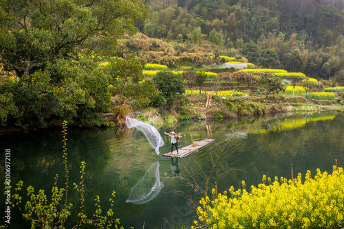 Schilderij op canvas Aerial View of Fishermen cast nets to catch fish in Jiangling Village, Wuyuan, J