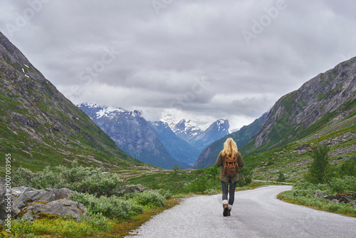 Mountain, trekking and woman on road for adventure, mockup space and fresh air on journey or travel. Outdoor, person and hiking on weekend, exploration and backpacking with view of valley or scenery