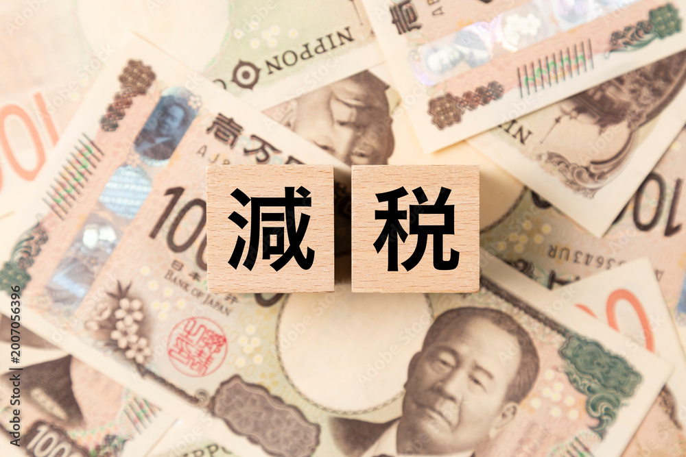 Fototapeta premium 「減税」と書かれたブロックとたくさんの一万円札 