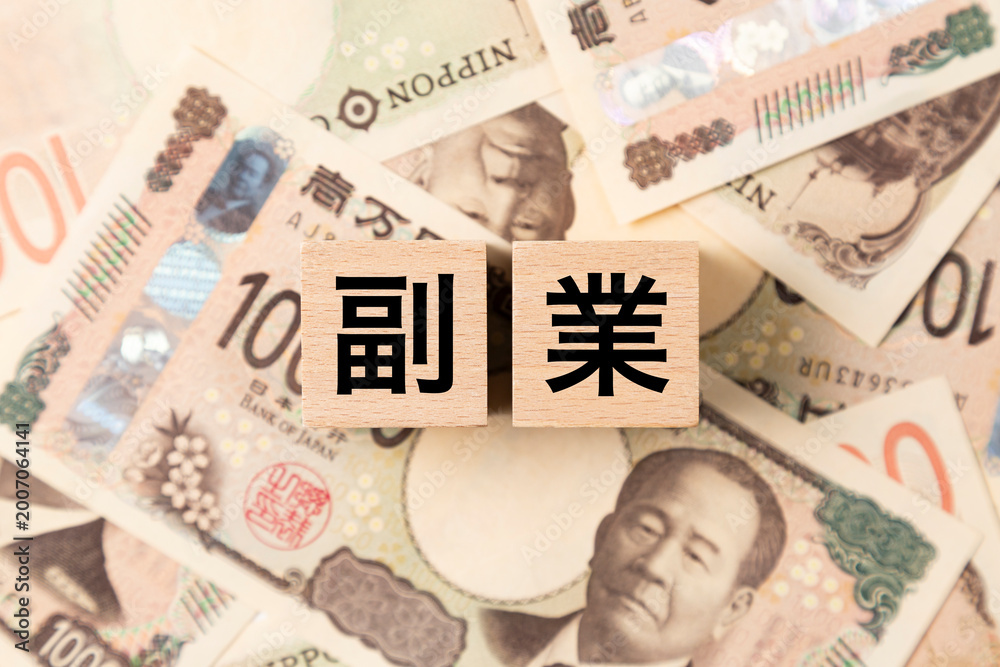 Fototapeta premium 「副業」と書かれたブロックとたくさんの一万円札