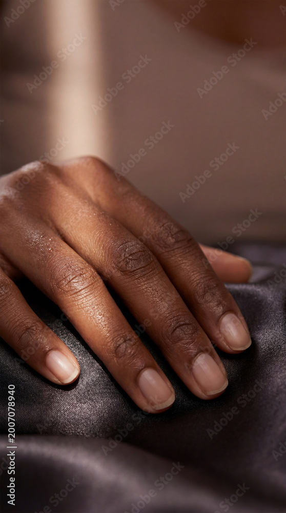 Fototapeta premium Macro hand on silk fabric in soft light