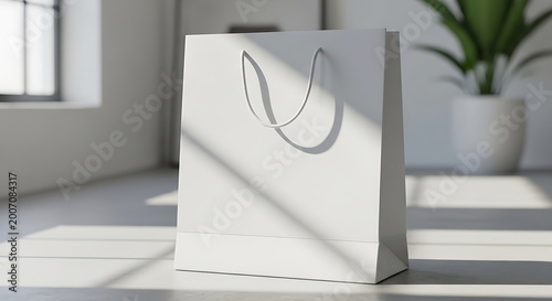 Blank white paper shopping bag with rope handles standing on a floor in a bright sunlit room
