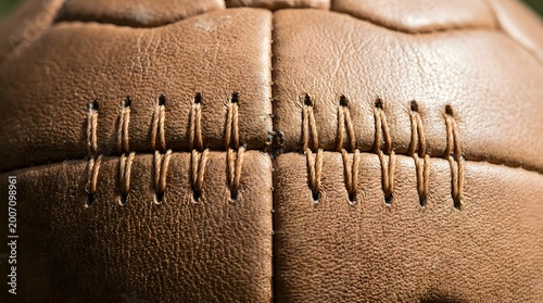 Macro detail of vintage leather football stitching and brown textured panels.