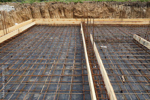 Steel reinforcement is placed in wooden molds and formwork on a construction site
