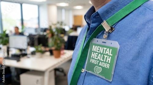 Mental Health Workplace Policy concept. Mental health first aider badge worn in an office environment.