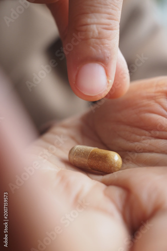 Fotografie Person placing capsule in hand for health purpose