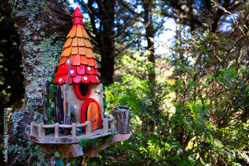 Фотография Whimsical red and orange fairy house attached to a forest tree