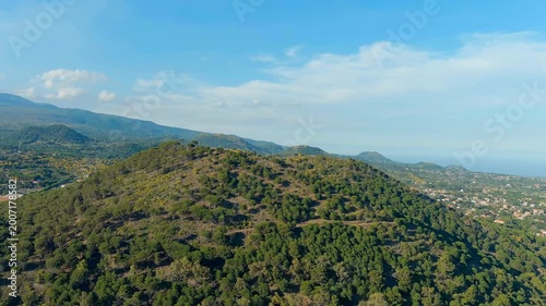 Nicolosi, Sicily, Italy. Volcanic craters overgrown with forest on the slopes of Mount Etna. Drone footage