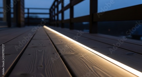 Low profile LED light strip seamlessly integrated into a wooden deck for subtle outdoor illumination