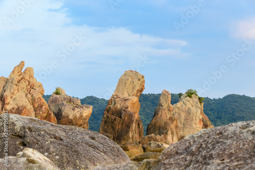 Grand landscape of Hashigui-iwa rocks in Kushimoto, Wakayama, Japan, with unique rock formations standing against a blue sky