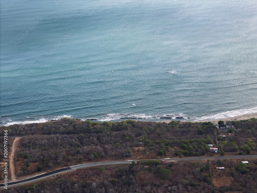 Fototapeta premium Coastline view from above near a road and water in daytime