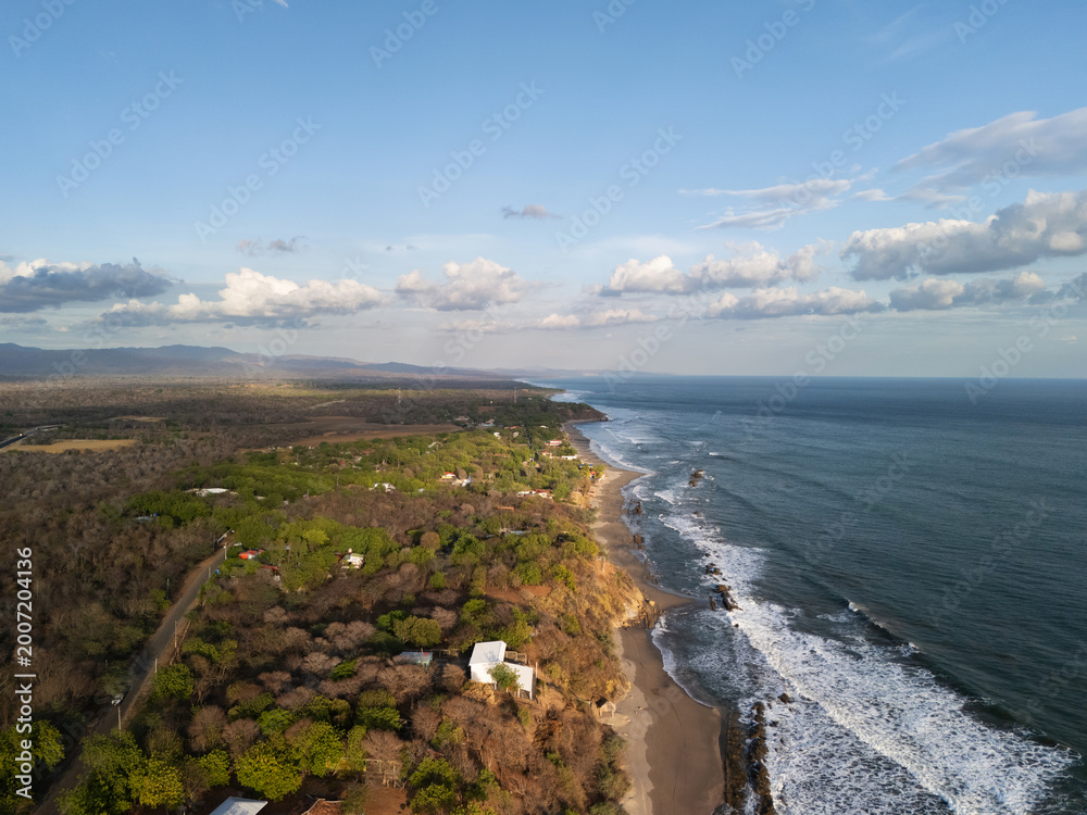 Fototapeta premium View of coastal landscape with waves and green land near beach