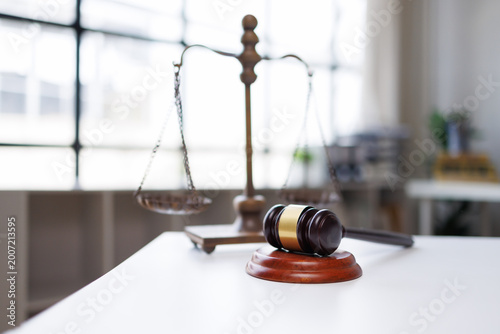 Fotografie Justice scales and a wooden gavel resting on a white table, symbolizing equality