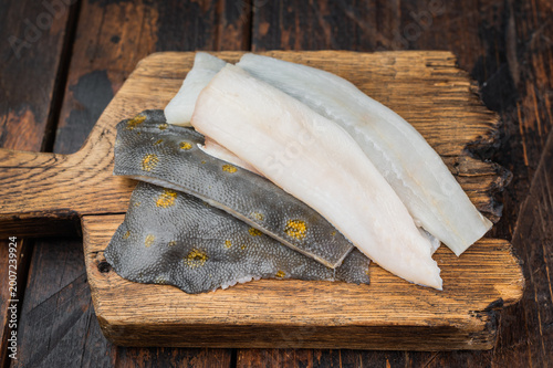 Slika na platnu Fresh plaice flatfish fillets on wooden board with spices raw seafood ingredient