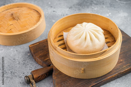 Foto Nikuman steamed bun served in bamboo steamer, fluffy Asian dumpling with soft do