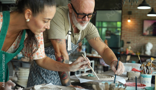 A happy couple makes ceramic plates in a workshop