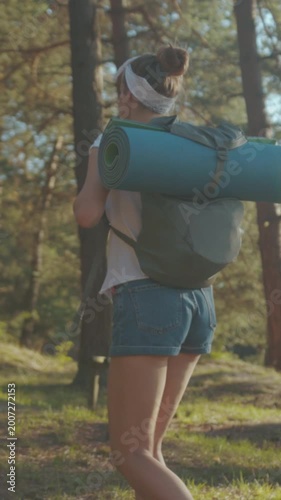 Vibrant outdoor scene depicting woman exploring nature during sunset with equipment and lively movement