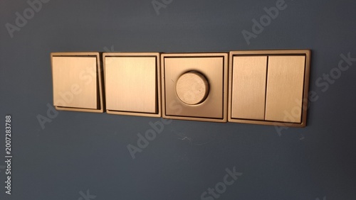 Tableau sur toile Modern gold light switches and dimmer on dark wall