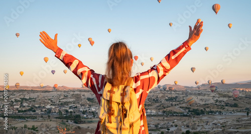 Obraz na plátně Hot air balloons float in the sky as a person enjoys the view at sunrise in Capp